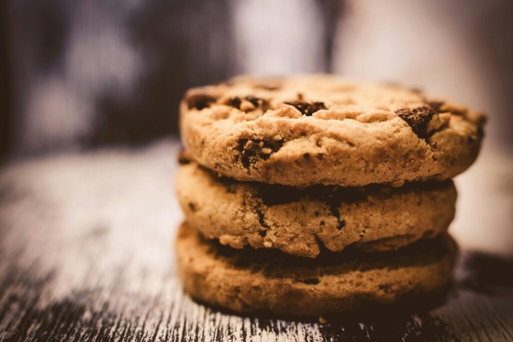 Una foto macro de galletas con chispas de chocolate recién horneadas crea un ambiente de postre acogedor.