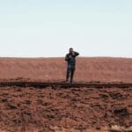 hombre resiliente saliendo de un desierto aprovechando para hacer una foto