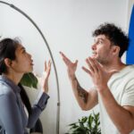 A couple argues indoors amidst greenery, showcasing emotions and interpersonal conflict.